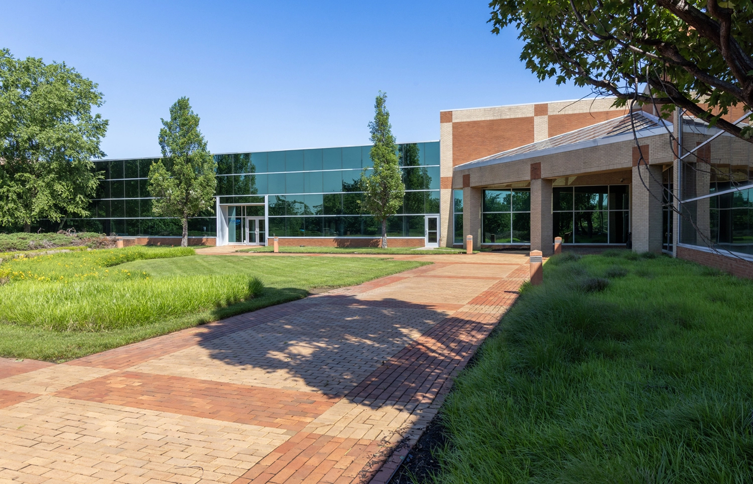 Lush green courtyard entrance to a brick life science building