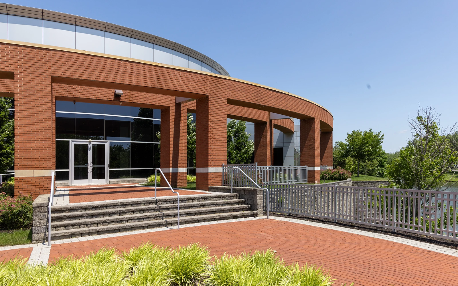 Corporate office lobby entrance with curved roofline and brick facade at Cedar Brook Cranbury