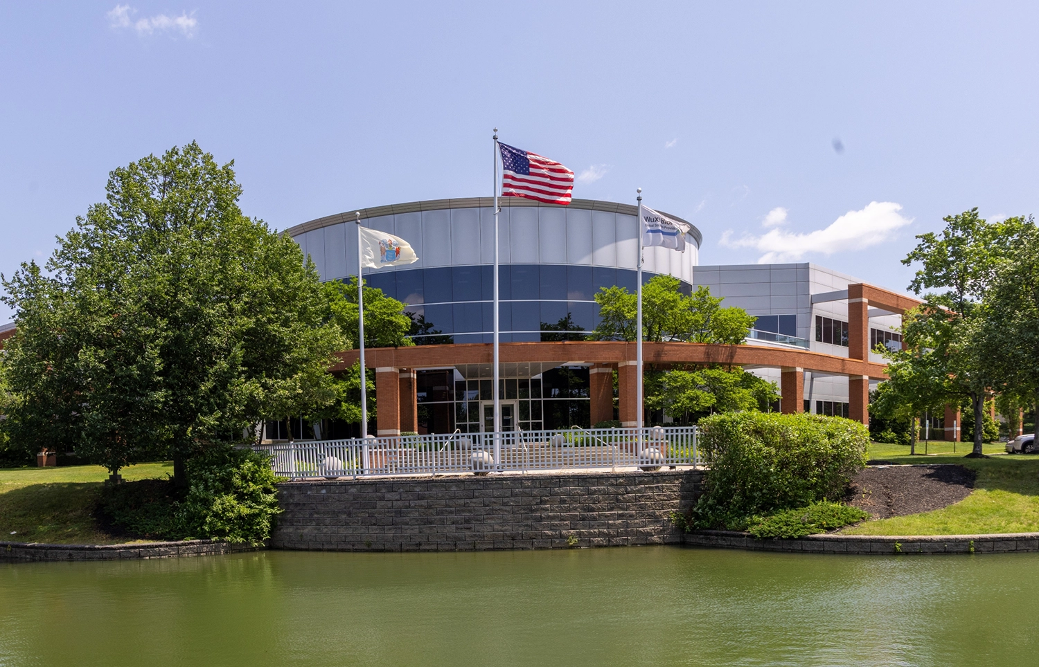 Modern office building with flags brick colonnade and landscaping at Cedar Brook corporate center