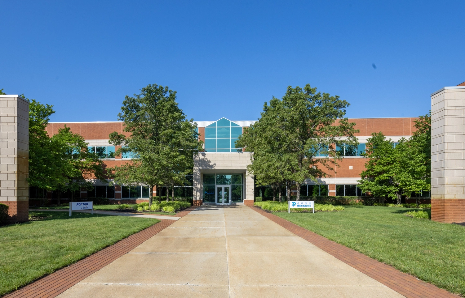 Wide sidewalk path to a brick office building in Cedar Brook