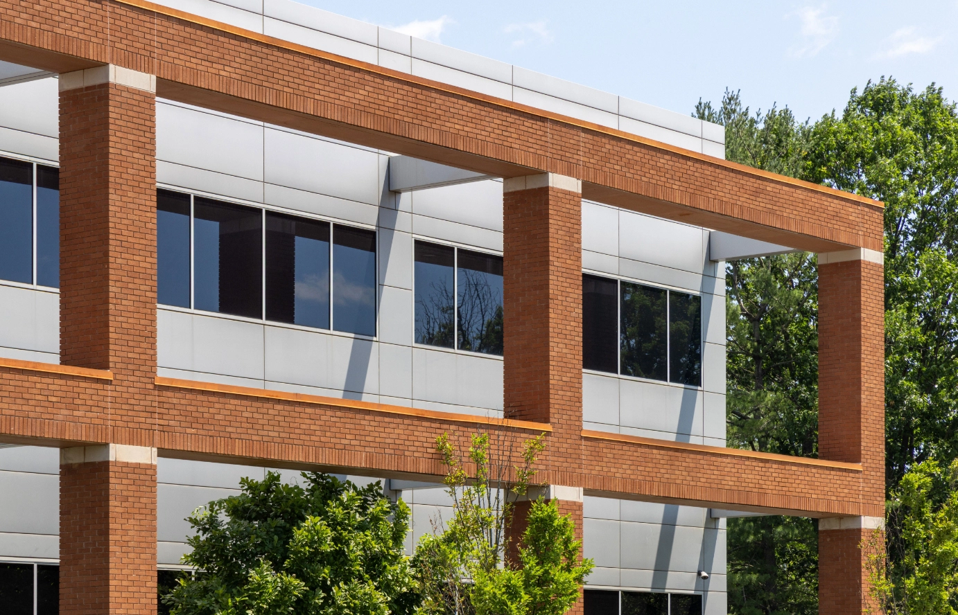 Architectural detail showing brick columns and glass windows on contemporary corporate building exterior