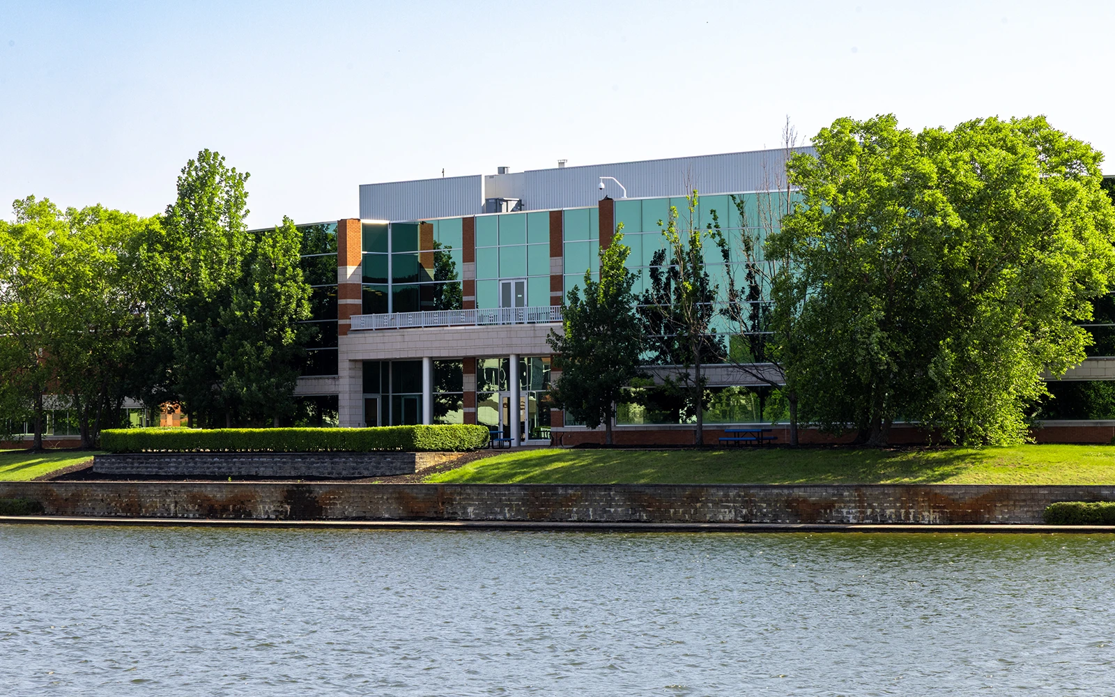 Professional office building with waterfront view reflective glass facade and landscaped campus surroundings