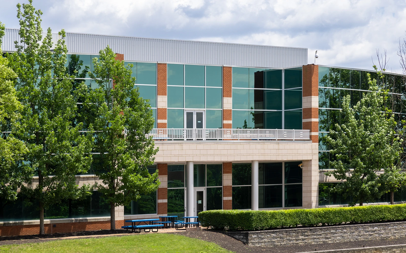 Professional business campus building with glass exterior upper balcony and manicured lawn