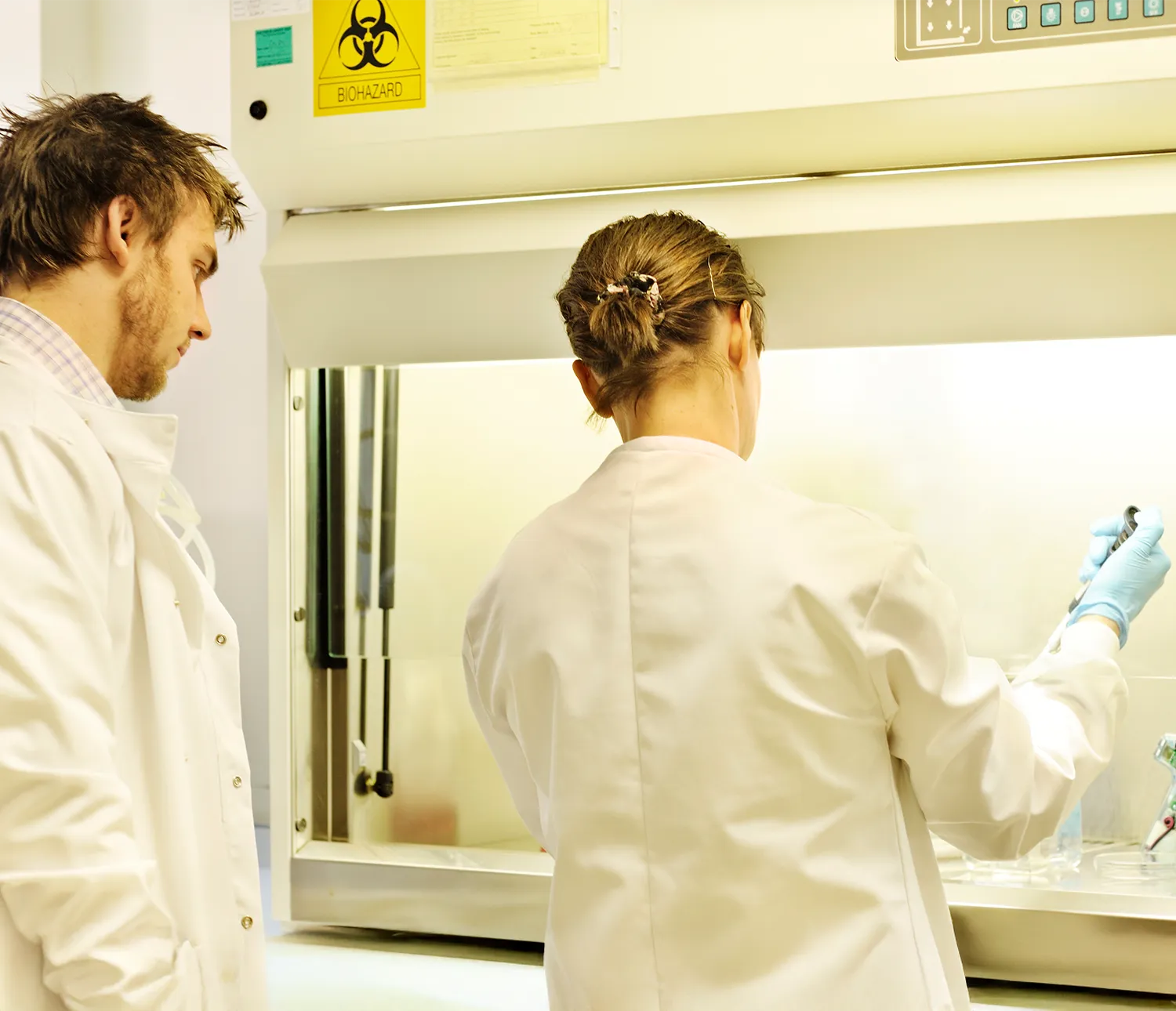 Research team conducting controlled laboratory testing with pipette and safety equipment present