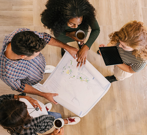 Team reviewing architectural site plan together during collaborative office planning session meeting